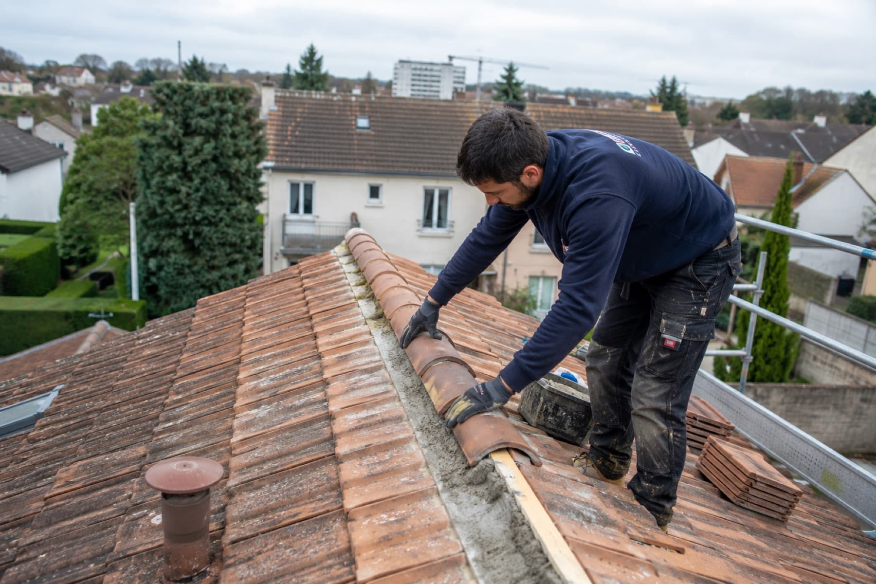 Couvreur au travail sur une toiture en tuiles